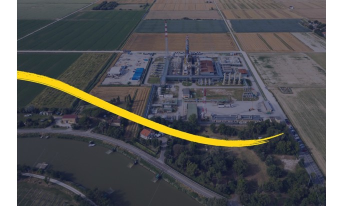 Veduta aerea di impianto industriale con pennellata gialla curva in basso.
