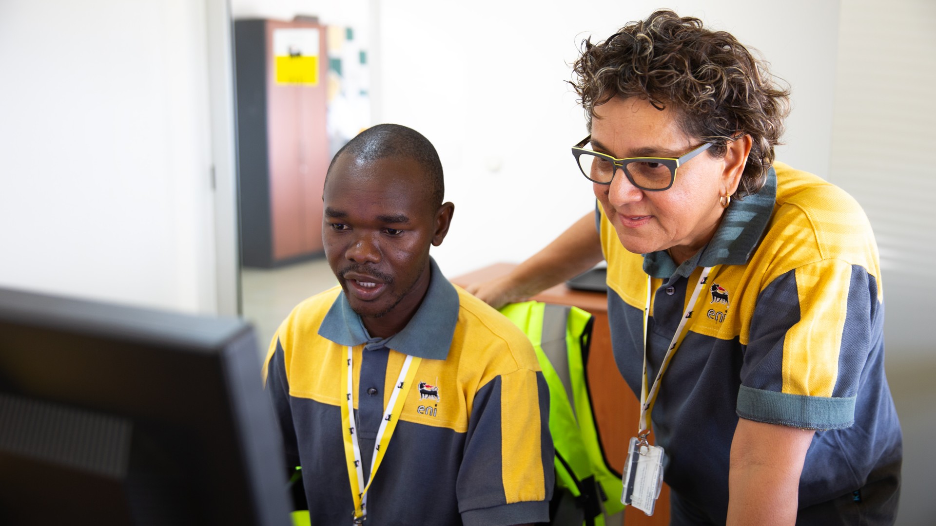 African woman and man talking in the office while looking at the computer