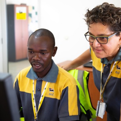 African woman and man talking in the office while looking at the computer