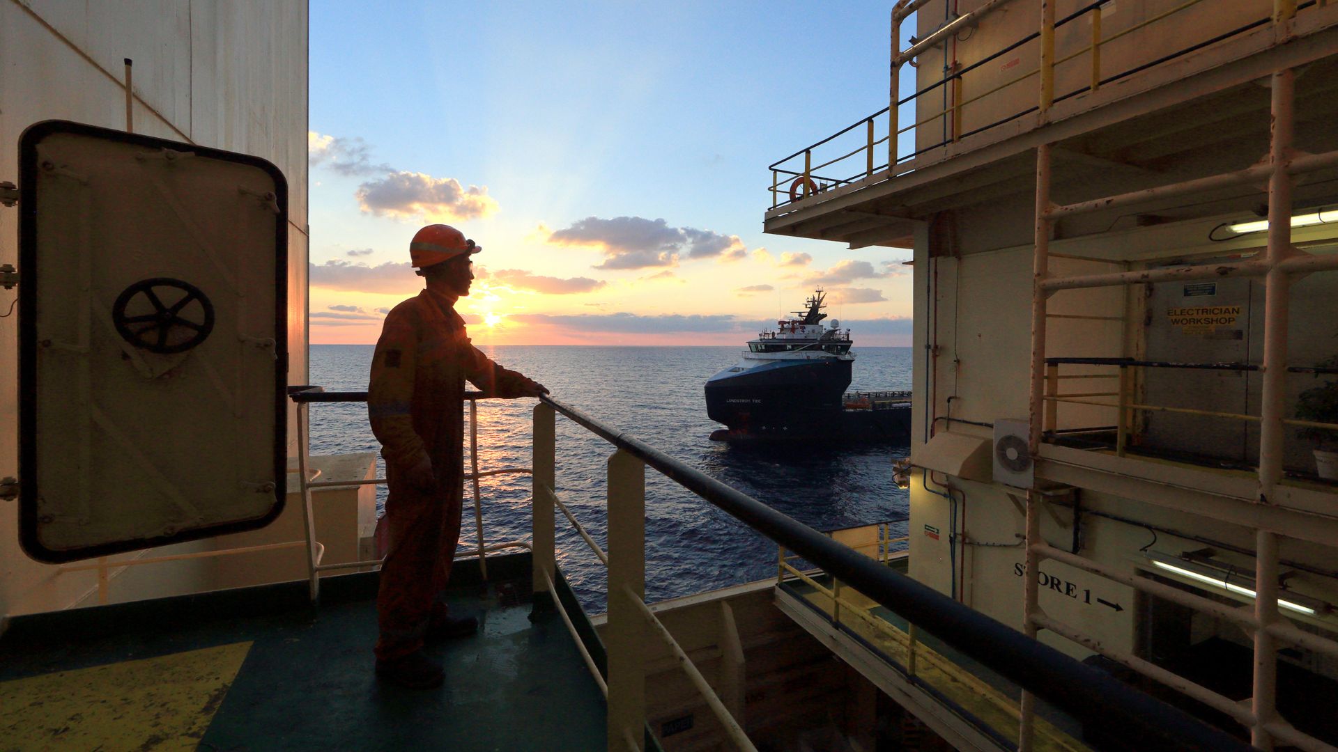 Worker on board the ship looks at the horizon