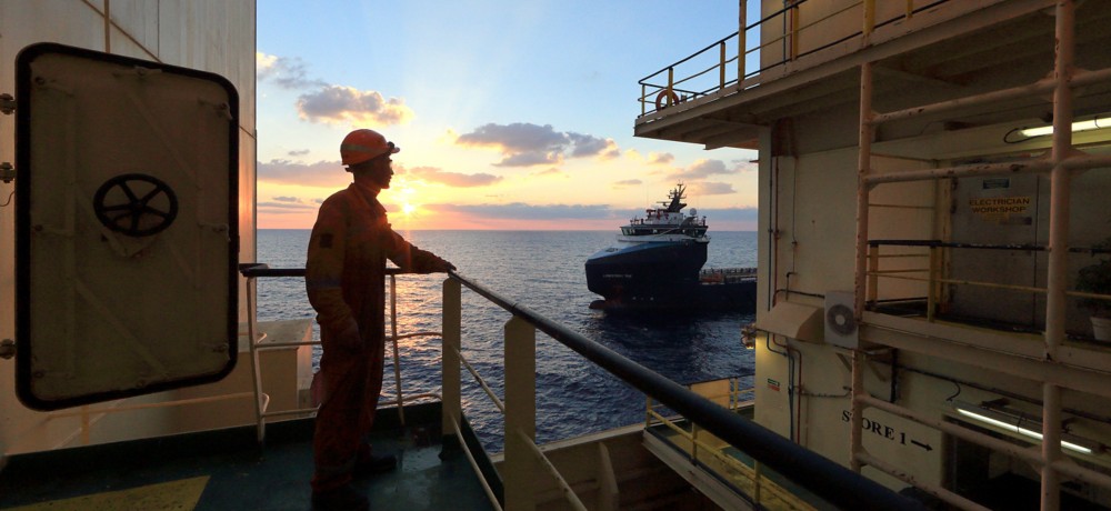 Worker on board the ship looks at the horizon