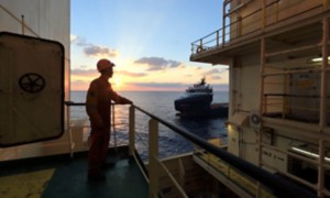 Operaio a bordo della nave guarda l'orizzonte