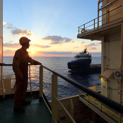 Worker on board the ship looks at the horizon