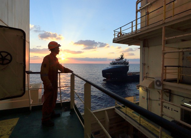 Worker on board the ship looks at the horizon