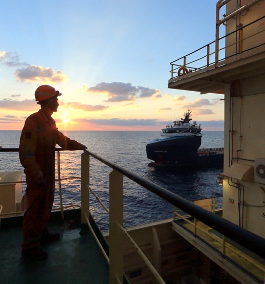 Worker on board the ship looks at the horizon