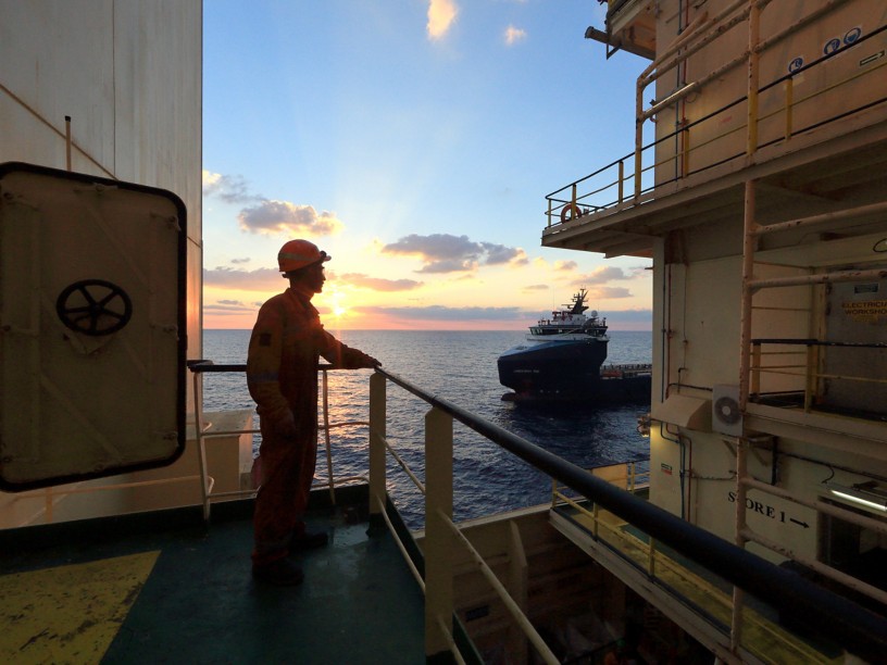 Worker on board the ship looks at the horizon