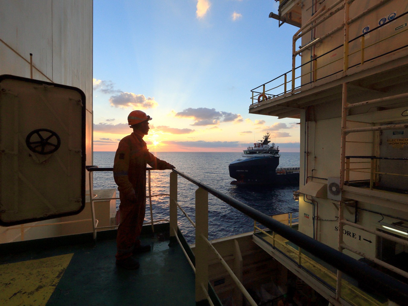 Worker on board the ship looks at the horizon