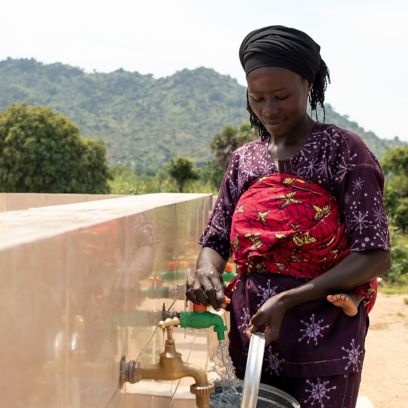 African woman takes water from well