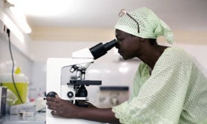 Dottoressa africana guarda attraverso il microscopio