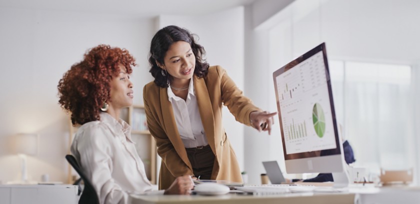 Due colleghe in ufficio guardano i dati a monitor