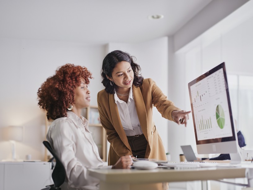 Due colleghe in ufficio guardano i dati a monitor