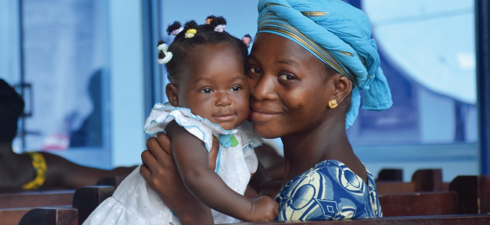 African woman embracing her baby girl