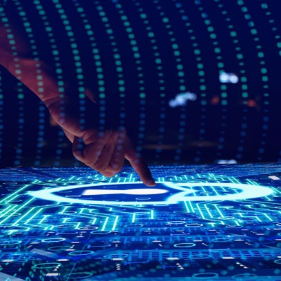 Hand touching an interactive screen with graphics