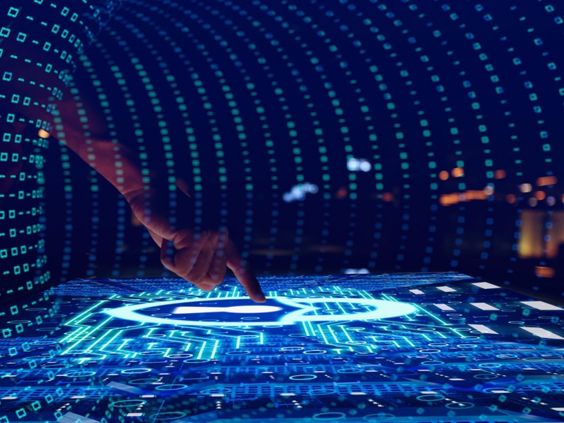 Hand touching an interactive screen with graphics