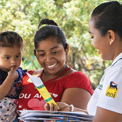 Mexican woman hands out information leaflet to Mexican woman with child