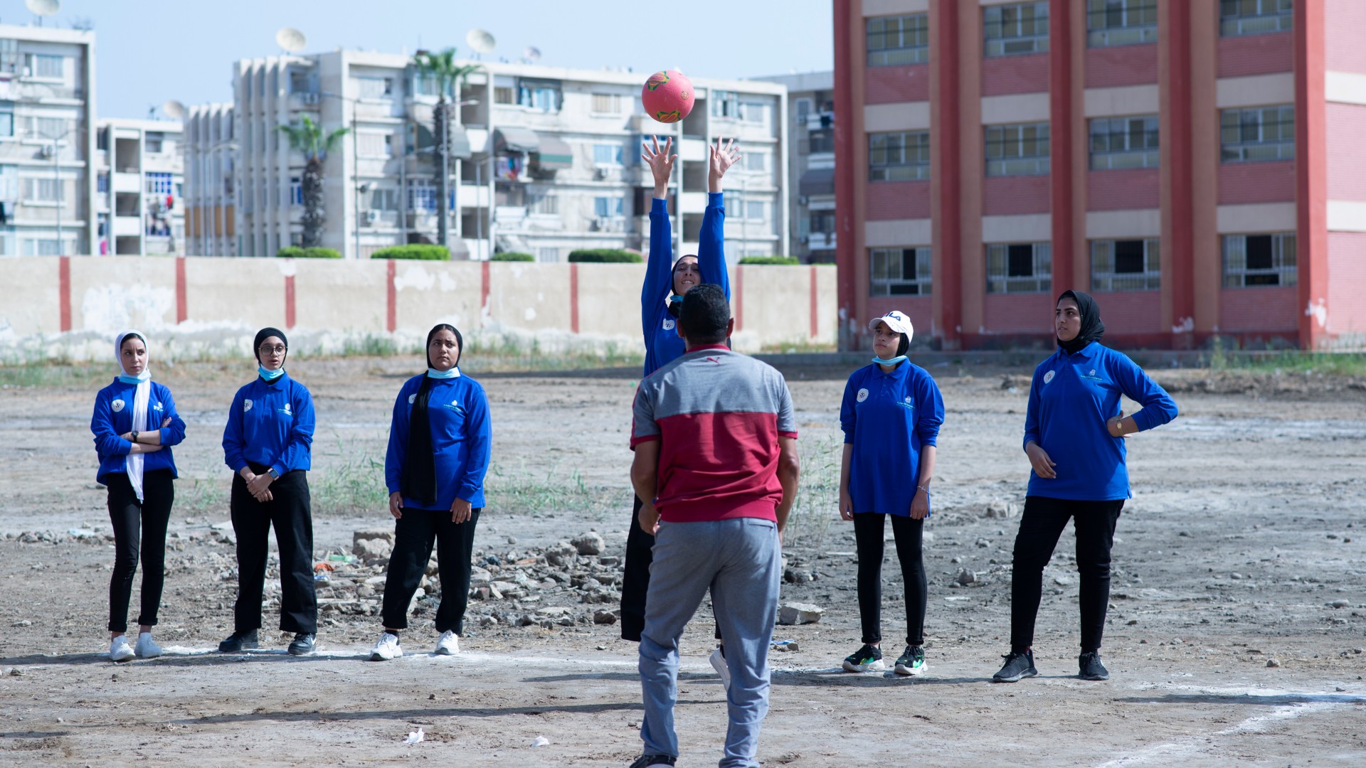 Gruppo di ragazzi gioca a palla in un campo di scuola