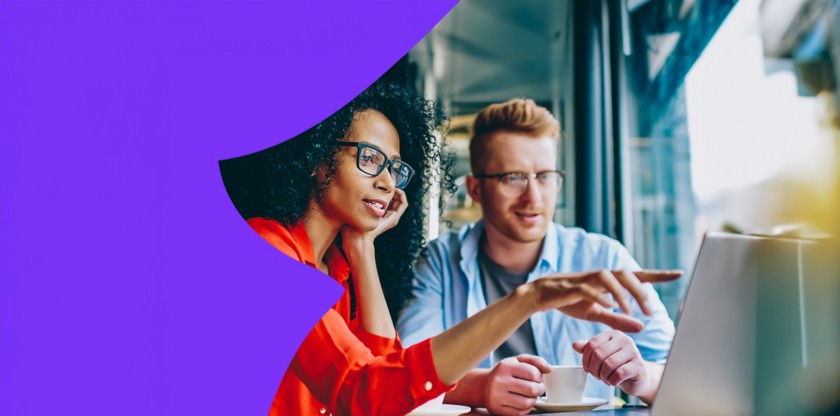 Uomo e donna con occhiali che lavorano insieme su un laptop.
