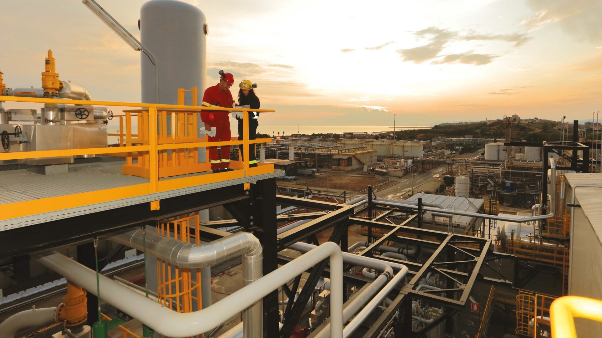 Workers over the Gela plant at sunset