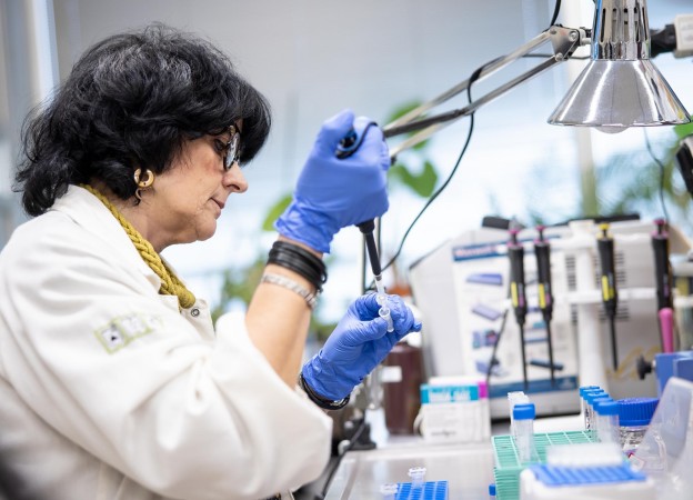 Scientist in laboratory testing test tubes