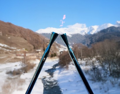 Due torce accese alle Olimpiadi di Cortina, con montagne innevate sullo sfondo