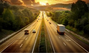 vista di un autostrada al tramonto con automobili e autoarticolati 