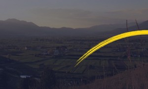 Paesaggio al tramonto con pennellata gialla curva in primo piano.