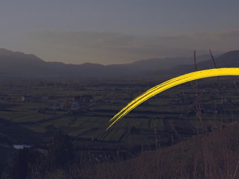 Paesaggio al tramonto con pennellata gialla curva in primo piano.
