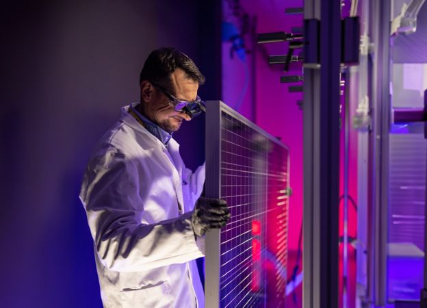 Scientist fixes solar panel in laboratory