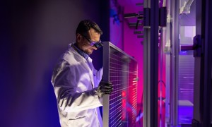 Scientist fixes solar panel in laboratory