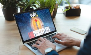 Persona al laptop con rivista digitale "we." e copertina futuristica.