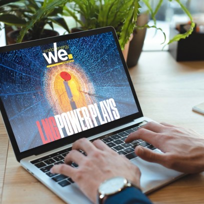 Person on laptop viewing digital magazine "we." with futuristic cover.