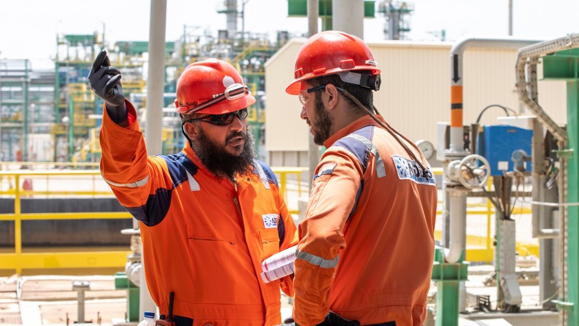 Two workers check the plant