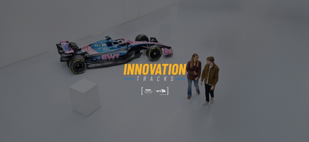 Auto da Formula 1 BWT Alpine in esposizione con livrea blu e rosa, sponsor visibili e scritta “INNOVATION TRACKS”.