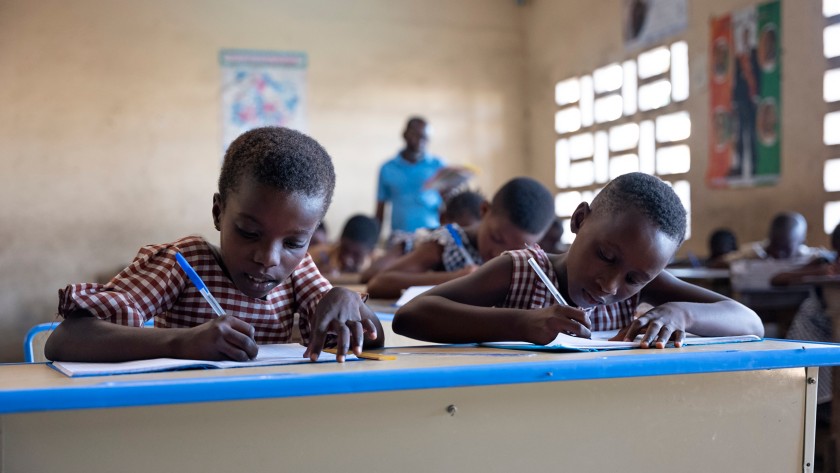 Two African children write during class lesson