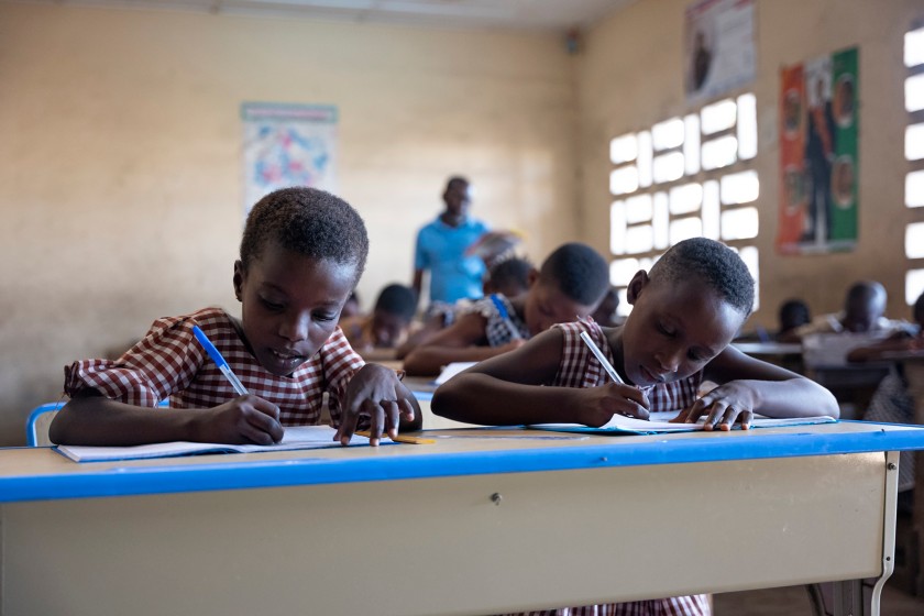 Due  bambini africani  scrivono durante la lezione in classe