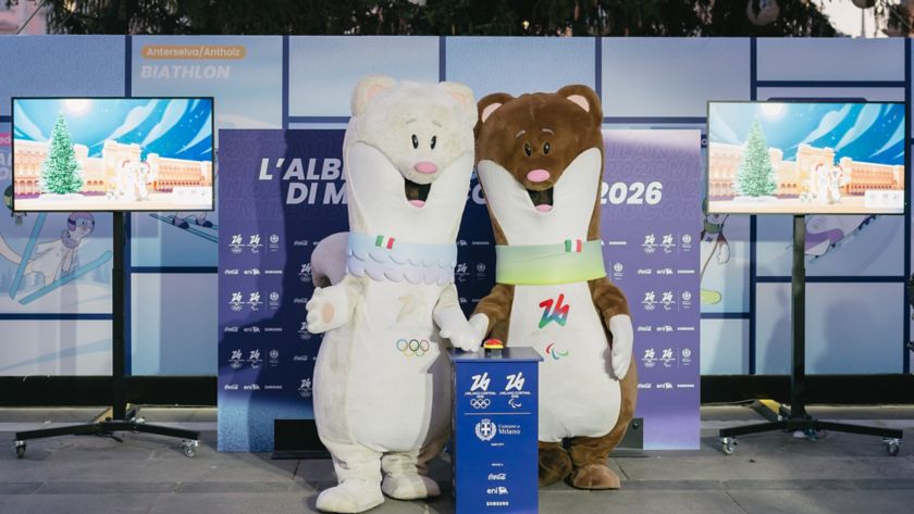 Le Mascotte Tina e Milo con dietro l'Albero dei Giochi di Milano Cortina 2026 in Piazza Duomo a Milano.