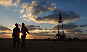 Two workers walk through the plant during sunset light