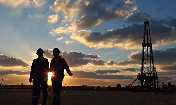 Due operai camminano nell’impianto durante la luce del tramonto