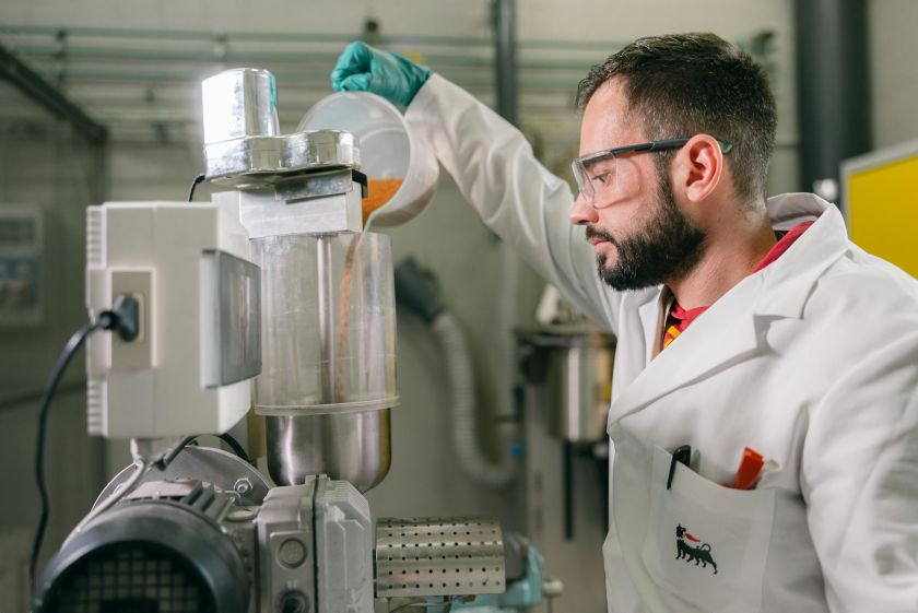 Scientist inserts raw material into machine