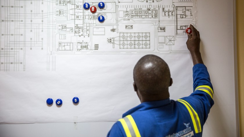 African worker writing on the map