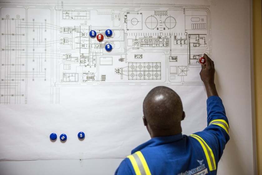 African worker writing on the map