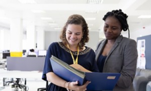 Due impiegate Eni guardano documenti in ufficio