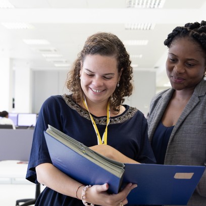 Two Eni employees look at documents in the office