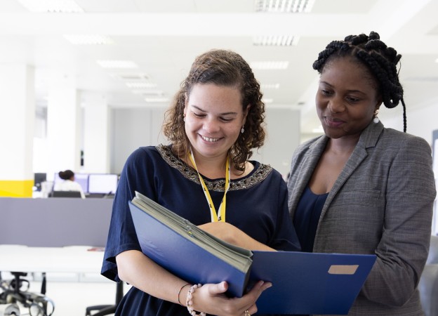 Two Eni employees look at documents in the office