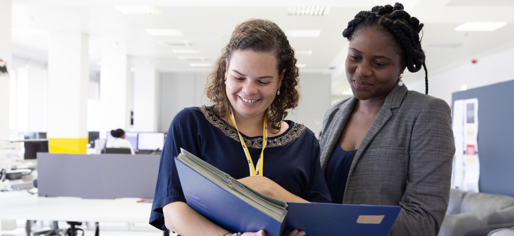 Two Eni employees look at documents in the office