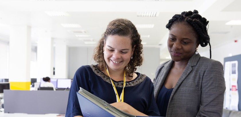 Two Eni employees look at documents in the office