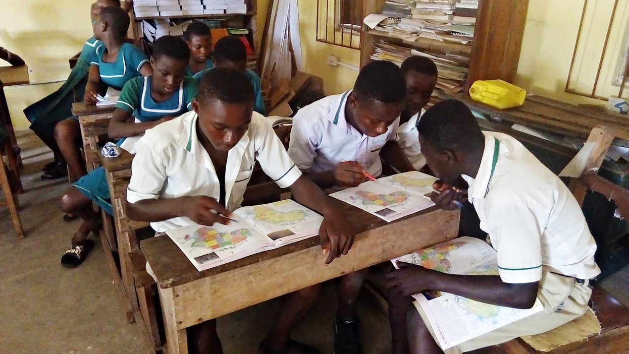 Foto di gruppo di ragazzi africani studiano i libri di geografia 