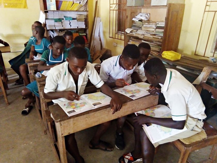 Foto di gruppo di ragazzi africani studiano i libri di geografia 