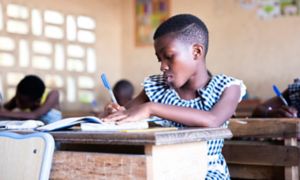 Bambina africana scrive durante la lezione a scuola