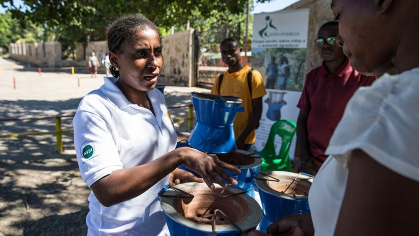 Donna  africana consegna sistema di cottura  alla comunità